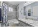 Updated bathroom with gray tile surround, shower-tub combination, and marble vanity at 6263 E Duncan St, Mesa, AZ 85205