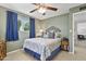 Green bedroom featuring a ceiling fan, window with blue curtains, and queen-size bed at 6263 E Duncan St, Mesa, AZ 85205