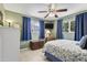 Cozy bedroom with a ceiling fan, two windows with blue curtains, and tile floor at 6263 E Duncan St, Mesa, AZ 85205