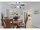 Dining room view with slider, table, chairs, view into kitchen, and ceiling fan at 6263 E Duncan St, Mesa, AZ 85205