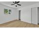 Bright bedroom featuring a large window, sliding closet doors, a ceiling fan and modern flooring, showcasing a clean space at 7137 N 22Nd Dr, Phoenix, AZ 85021