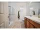 Bright bathroom featuring double sinks with wood cabinets, tile flooring, and combined shower with tub at 9912 W Illini St, Tolleson, AZ 85353