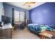 Cozy bedroom features blue painted walls, a ceiling fan, a window with blinds, and carpet floors at 9912 W Illini St, Tolleson, AZ 85353