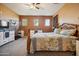 Bedroom boasts carpet, a ceiling fan, three windows, a dresser, and a TV for relaxation and entertainment at 9912 W Illini St, Tolleson, AZ 85353