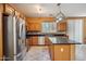 Updated kitchen features stainless steel appliances, center island with granite countertops and modern lighting at 9912 W Illini St, Tolleson, AZ 85353