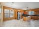 Open kitchen with stainless steel appliances, center island with granite countertops and tile floors at 9912 W Illini St, Tolleson, AZ 85353