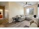 Inviting living room features wood flooring, a ceiling fan, natural light, and comfortable furniture at 9912 W Illini St, Tolleson, AZ 85353