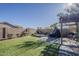 Wide backyard with stone landscaping, artificial grass, outdoor kitchen, covered patio and privacy wall at 11101 E Abilene Ave, Mesa, AZ 85208