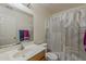 Well-lit bathroom features a single sink vanity, toilet, and shower with a patterned curtain at 11101 E Abilene Ave, Mesa, AZ 85208