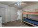 Inviting bedroom featuring a bunk bed, ceiling fan, and a closet with sliding doors at 11101 E Abilene Ave, Mesa, AZ 85208
