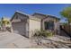 Single Gathering home featuring a two-car garage, desert landscaping, and sandstone accents at 11101 E Abilene Ave, Mesa, AZ 85208
