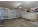 Spacious garage with concrete flooring, a roll-up door, and ample storage space on shelves at 11101 E Abilene Ave, Mesa, AZ 85208