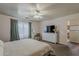 This bedroom has a ceiling fan, television, and a chair with an ottoman at 11101 E Abilene Ave, Mesa, AZ 85208