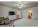 The bedroom features a TV, a ceiling fan, and neutral colored carpet at 11101 E Abilene Ave, Mesa, AZ 85208