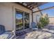 Covered patio area with sliding glass door, chairs and neat stone and grass landscaping at 11101 E Abilene Ave, Mesa, AZ 85208