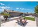 An outdoor space features a picnic table, a gray house, and a gravel area to the left, providing a relaxing environment at 11450 E Elton Ave, Mesa, AZ 85208