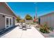 Backyard features outdoor furniture, rock landscaping, turf, and double doors to the house at 11450 E Elton Ave, Mesa, AZ 85208