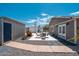 Backyard with rock landscaping, patio with seating, double doors, and storage shed at 11450 E Elton Ave, Mesa, AZ 85208