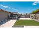 A well maintained backyard with artificial grass, hardscape, and a covered space for a car, ensures a neat and tidy outdoor area at 11450 E Elton Ave, Mesa, AZ 85208
