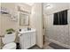 Cozy bathroom features a white vanity, toilet, decorative wall art, and a shower with a patterned curtain at 11450 E Elton Ave, Mesa, AZ 85208