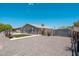 View of property with gravel landscaping, desert plants, block wall, and gate leading to the main house at 11450 E Elton Ave, Mesa, AZ 85208