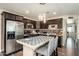 Modern kitchen with dark wood cabinets, stainless steel appliances, and stylish island with seating at 11450 E Elton Ave, Mesa, AZ 85208