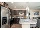 Well-equipped kitchen with stainless steel appliances, dark wood cabinets, and an island with modern pendant lighting at 11450 E Elton Ave, Mesa, AZ 85208