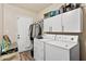 Functional laundry room with washer, dryer, storage cabinets, and access to the exterior at 11450 E Elton Ave, Mesa, AZ 85208