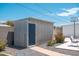A metal shed stands with a blue door, complimented by a basketball hoop and stone landscaping offering practical storage at 11450 E Elton Ave, Mesa, AZ 85208