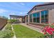 Well-manicured backyard featuring an outdoor patio, green grass, and beautiful landscaping at 129 E Los Andes Ln, Queen Creek, AZ 85140