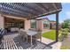 Outdoor patio with pergola and dining table, overlooking a well-maintained backyard at 129 E Los Andes Ln, Queen Creek, AZ 85140