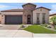 Charming home featuring a brick facade, a well-kept lawn, and an attached garage at 129 E Los Andes Ln, Queen Creek, AZ 85140