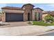 Charming home featuring a brick accents, a two-car garage and manicured artificial lawn at 129 E Los Andes Ln, Queen Creek, AZ 85140