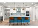 Modern kitchen with stainless steel appliances, stylish island, white cabinets, and pendant lighting at 129 E Los Andes Ln, Queen Creek, AZ 85140