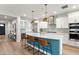 Open kitchen with a large center island, stainless appliances, modern lighting and hardwood floors at 129 E Los Andes Ln, Queen Creek, AZ 85140