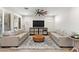 Bright living room with hardwood flooring, ceiling fan, neutral paint and modern furniture at 129 E Los Andes Ln, Queen Creek, AZ 85140