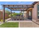 Outdoor patio featuring a dining table, a grill, and a pergola with string lights at 129 E Los Andes Ln, Queen Creek, AZ 85140