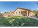 Expansive backyard with a covered patio, lush lawn, and built-in barbeque area at 12910 W Glenrosa Dr, Litchfield Park, AZ 85340