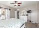This is a primary bedroom with a ceiling fan, large white dresser, tv and barn door to the bathroom at 12910 W Glenrosa Dr, Litchfield Park, AZ 85340