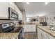 Open kitchen with stainless appliances, granite counters, and seamless connection to living area at 12910 W Glenrosa Dr, Litchfield Park, AZ 85340