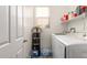 Bright laundry room featuring modern washer and dryer, shelving, and a convenient water cooler at 12910 W Glenrosa Dr, Litchfield Park, AZ 85340