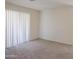 Bright bedroom featuring a carpeted floor and a large window with vertical blinds at 1336 E Laurel Pl, Casa Grande, AZ 85122