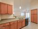 Well-lit kitchen showcasing wood cabinets, stainless steel sink, and a view of the adjacent living space at 1336 E Laurel Pl, Casa Grande, AZ 85122