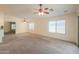 Expansive living room with neutral carpet, multiple windows, a ceiling fan, and access to the kitchen at 1336 E Laurel Pl, Casa Grande, AZ 85122