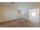 Spacious living room with neutral carpet, a window with blinds, and open access to other rooms at 1336 E Laurel Pl, Casa Grande, AZ 85122