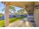Inviting covered patio with ceiling fans, synthetic grass, an outdoor kitchen, and views of the lush backyard at 1409 E Goldenrod St, Phoenix, AZ 85048