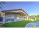 Expansive backyard featuring a covered patio, built-in grill, and manicured lawn at 1409 E Goldenrod St, Phoenix, AZ 85048