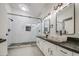 Bathroom featuring double sinks, stone vessel sinks, black counters, decorative lighting, and glass shower at 1409 E Goldenrod St, Phoenix, AZ 85048