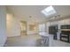 Bright kitchen features granite counters, skylight, island, tile floors, white cabinets, and black appliances at 1409 E Goldenrod St, Phoenix, AZ 85048