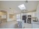 Bright kitchen features granite counters, skylight, island, tile floors, white cabinets, and black appliances at 1409 E Goldenrod St, Phoenix, AZ 85048